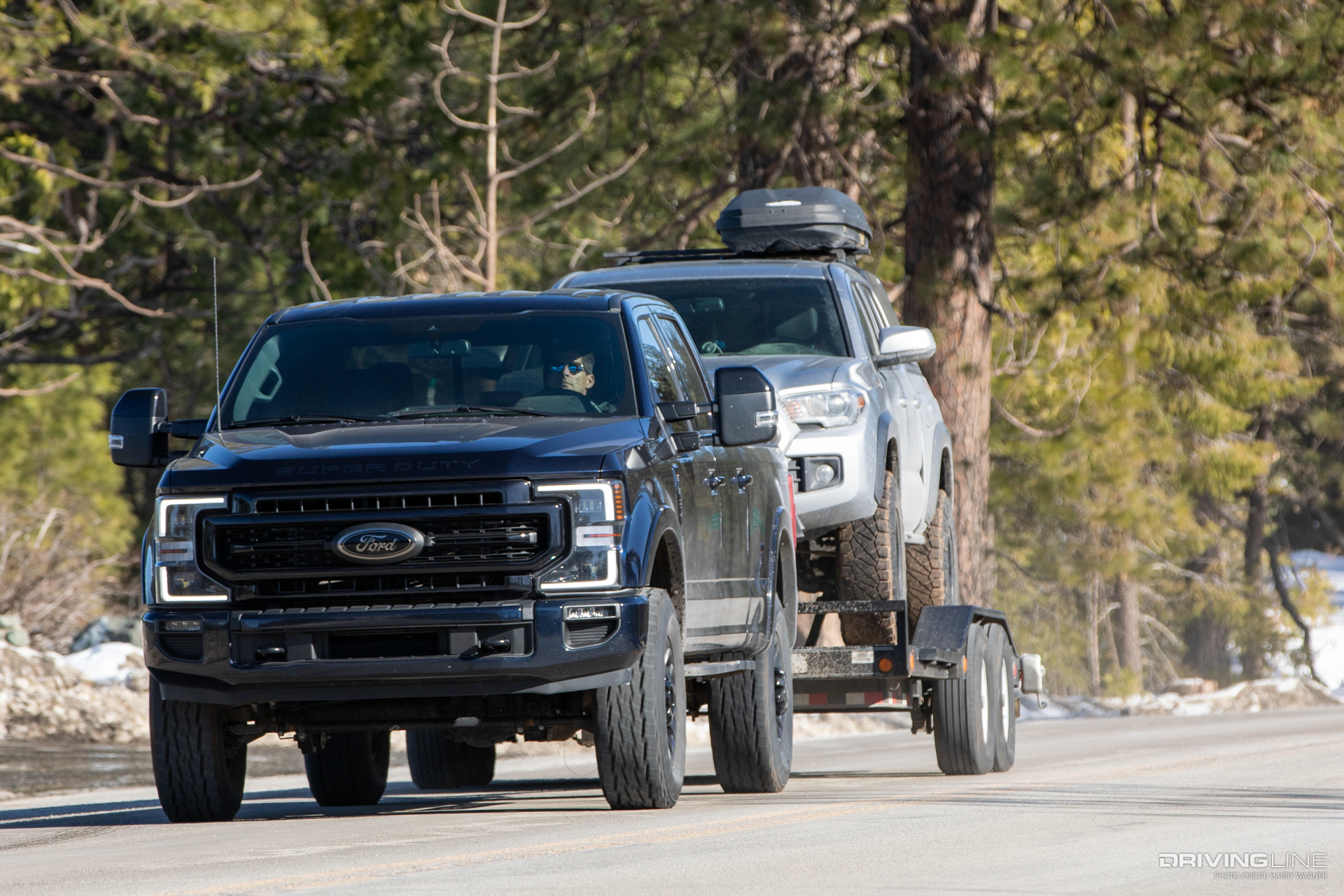 Black Ford F250 towing a silver truck