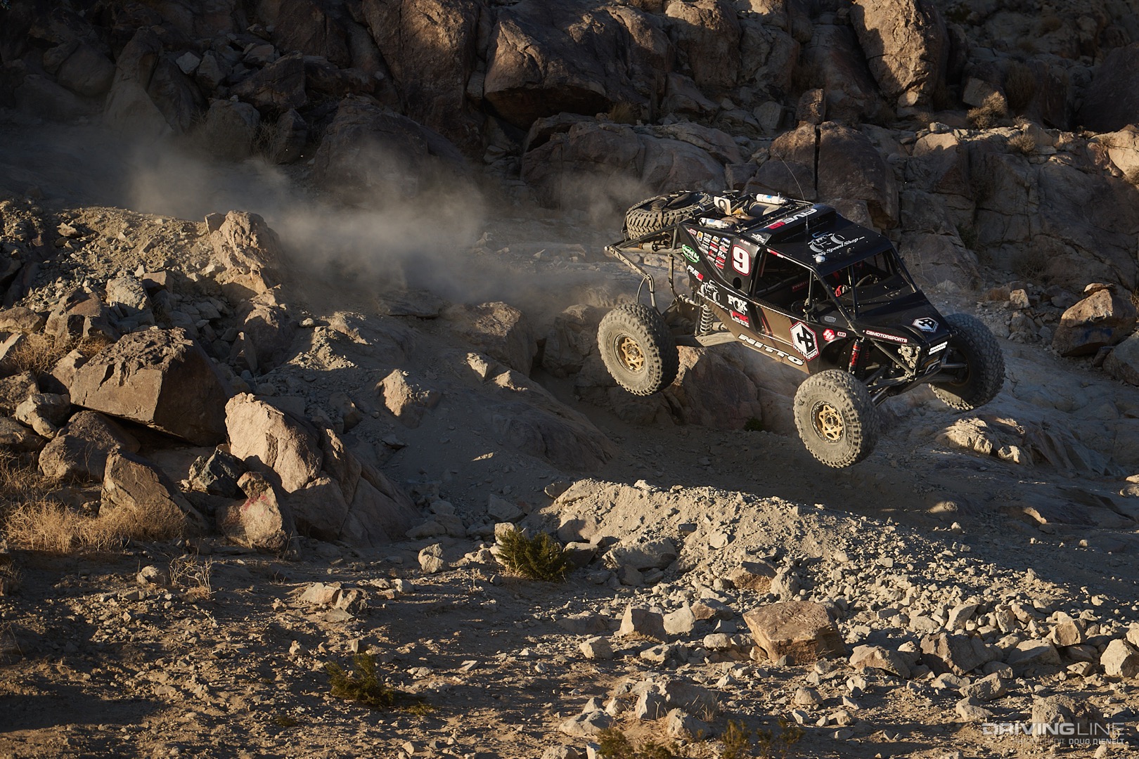 Byran Crofts driving off a large rock