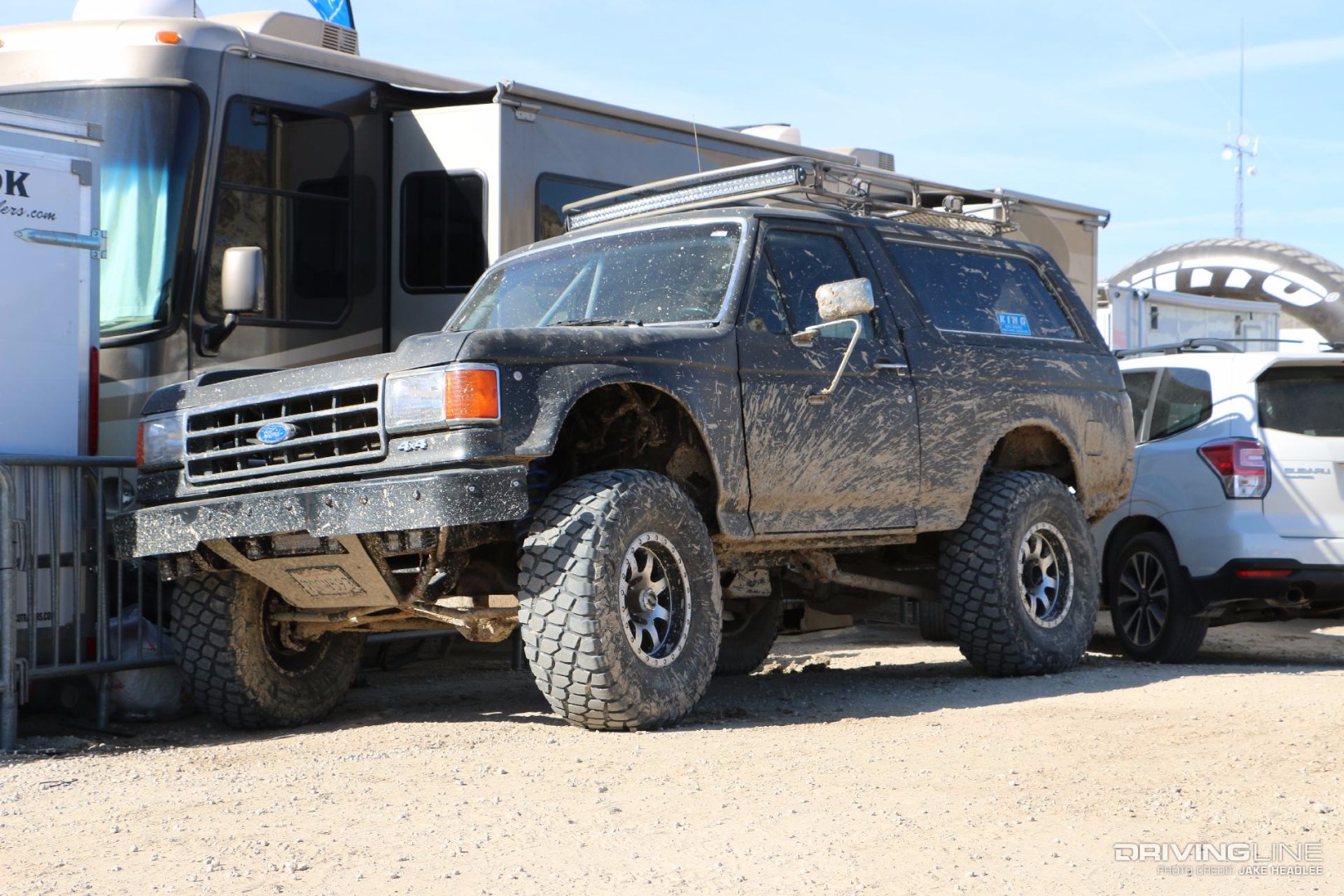 Muddy Ford Bronco parked in front of an RV