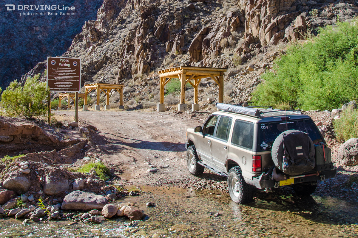 4x4 at the entrance to a camping area with public parking sign