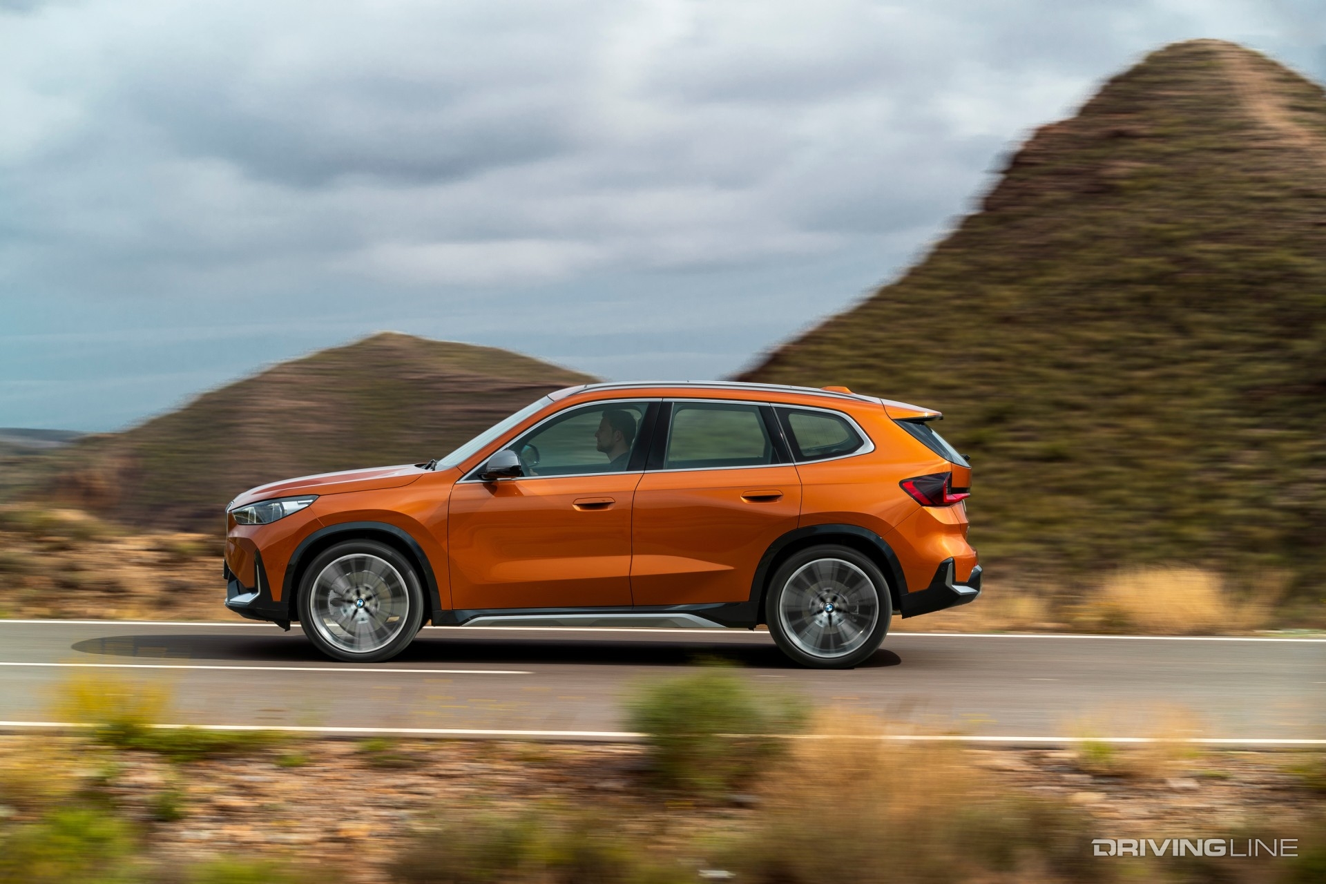 2023 BMW X1 in orange side profile on the road